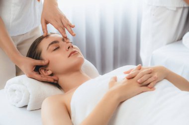 Kafkasyalı kadın stres önleyici kafa masajından ve lüks tatil beldesi ya da otel spa salonundaki modern ışık ortamında yüz güzelliği eğlencelerini şımartmaktan hoşlanıyor. Sessiz.