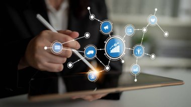 Bir iş adamı dijital büyüme sembollerini gösteren, modern teknolojiyi, veri analizini ve iş yerindeki bağlantıyı temsil eden bir tabletle ilgilenir. Tessel