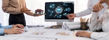 İç mimar tasarımcı grubu, daha kesin tasarım için planlar ve dizüstü bilgisayar ekran mimari yazılımı üzerinde birlikte tartışıyorlar. Modern ev tasarımı ve yenileme. İçgörü