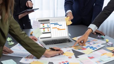 Analizci ekibi yaratıcı ve analitik beyin fırtınası fikri için bilgisayar ekranında BI veri paneli olan yapışkan bir not kullanıyor. Pazarlama stratejisi için finansal veri görselleştirme teknolojisini analiz et. Dahi.