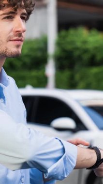 İş adamı, istasyonun otoparkından şarj olurken akıllı telefon hologramındaki EV aküsünün durumunu kontrol ediyor. EV teknolojisi adaptasyonu için temiz enerjinin gelecekteki yaşam tarzı. İnceleyin