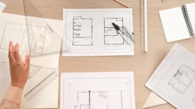 Ölçüm aracı ve kalem kullanan akıllı mimar ya da mühendisin videosu mimari ofisteki inşaat doğruluğu için bir el taslağı ayrıntılı taslağını karşılaştırıyor. Eline odaklan. - Yakın çekim. Tanımlama.