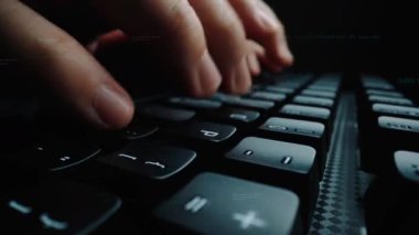 Kod grafikleriyle çevrili bir klavyede el yazısının yakın plan görüntüsü. Bu resim yazılım gelişiminin ve dijital çalışma alanının özünü yakalar. Xenic