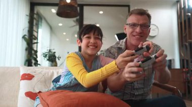 Büyükbaba ve torun birlikte konsol oyunu, eğlence medyası oynuyorlar. Eski kullanım teknolojisi yeni nesil ile iletişim kurar. Nesiller arası uçurum aile bağını güçlendirir. Uyumsuzluk.