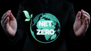 Çevresel girişimleri ve sürdürülebilirliği temsil eden simgelerle çevrili, parlayan yeşil bir küreyi 