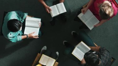 İncil 'i okuyup, kucağında İncil' le daireler çizerek otururken en tepeden aşağı dua manzarası. İnanç, güven ve umut ve sükunetle çalışırken farklı insanların kitaba bakışları. Sempozyum.