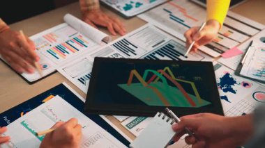 Dinamik bir iş ekibi dijital tablet kullanarak veri analizi üzerinde işbirliği yapıyor. Görüşmede trendler ve performans ölçümleri, modern bir ofiste stratejik karar verme mekanizmasının geliştirilmesi ele alınıyor. SACTR