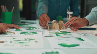 Etkili iş stratejileri ve büyüme için yeşil sürdürülebilirlik grafikleri ve verileri analiz eden dinamik bir ekip, modern bir ofis ortamında işbirliği içine girer. SACTR