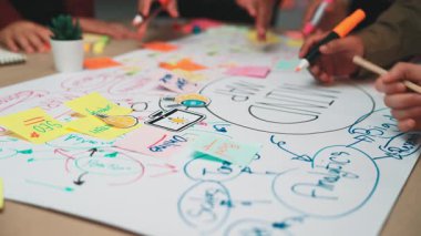 Renkli yapışkan notlar üzerine fikirlerin özetlenmesinde aktif rol alan ve yaratıcı bir çalışma alanındaki takım çalışmasını vurgulayan dinamik bir beyin fırtınası oturumu. SACTR