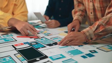 Heyecan verici bir dijital tasarım projesinde yer alan çeşitli profesyonellerden oluşan bir ekip, parlak ve modern bir çalışma alanında fikir ve çizimleri işbirliği içinde tartışıyor. SACTR