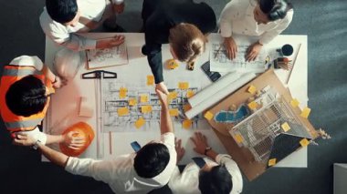 Yetenekli mühendis ekibinin proje planına bakarken konuştuğu en üst seviye görüntü. Birlikte çalışan ve mühendislik inşaatı için plan yapan bir grup akıllı iç mimar. Hizalama.
