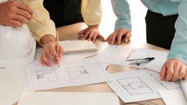 Mimari döküman, ölçüm araçları ve ahşap blokların modern ofiste etrafa saçıldığı masa üzerine planlar yapma konusunda akıllı mimar ve güvenlik mühendisi tartışması. - Yakın çekim. Tanımlama.