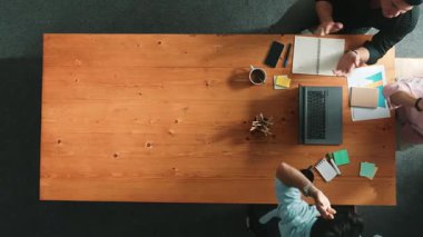 Akıllı iş adamlarının el çırparken dizüstü bilgisayara baktığı ve başarılı bir projeyi kutlamak ya da toplantıdaki satışları artırmak için beşlik çaktığı en tepeden aşağı hava görüntüsü. Cemaat.