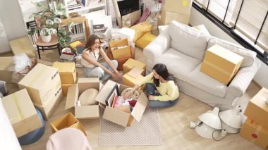 Oturma odasında karton kutuyla oturan mutlu çift kutudan mobilya topluyor. Lezbiyen aşığın yeni bir daireye ya da eve taşınırken konuştuğu en iyi manzara. Kız aşkı. Myrmidon.