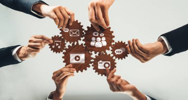 A visually engaging representation featuring multiple hands working together to connect various digital media icons within gears, symbolizing teamwork and collaboration in technology. Amity