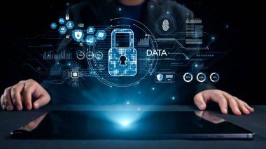 Bu resim dijital güvenlik simgeleriyle dolu bir tablet üzerindeki elleri tasvir ederek, günümüz teknolojisi odaklı dünyasında veri koruması ve siber güvenliğin önemini vurguluyor. Dörtgen