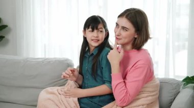 Annesi peri masalı anlatırken, mutlu kız beyaz annelerin kucağında oturuyor. Anne, kızı eve bakıp gülümserken ona sıcak bir şekilde sarılıyor. Aile birlikte vakit geçirir. Pedagoji.