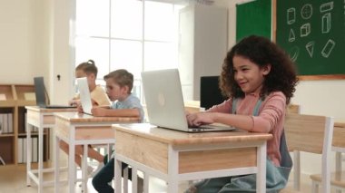 Amerikalı kız kodlama mühendisliğini öğrenirken çeşitli öğrenciler BTMM Teknoloji sınıfında oturuyor. Bilgisayarda çalışan çok kültürlü çocuklar yapay zeka üretmek için yazılım kullanıyorlar. Pedagoji.