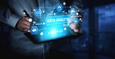Professional examines tablet device displaying advanced data analytics hologram, emphasizing technology role in modern business strategy and decision making. Tessel