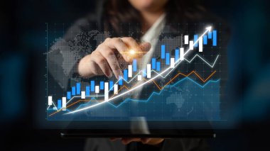 A business professional engages with digital graphs showcasing financial growth trends, emphasizing data analysis and market insights in an advanced workspace. Impute