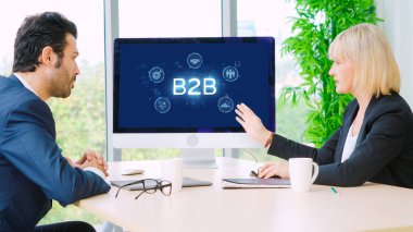 İş adamı B2B peyzajında geziniyor, iş-iş bağlantılarını geliştirmek için kullanım teknolojisi kullanıyor. B2B etkileşimini yeniden şekillendiren keşifler, iş-iş stratejilerinde yenilikleri yönlendiren araçlar. canlı