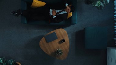 Stresli patronun yukarıdan görünüşü dizüstü bilgisayardaki satışları düşürüyor ve kanepede yatıyor. Yorgun yönetici stresliyken dizüstü bilgisayarda çalışıyor. İşinde başı ağrıyan yetenekli bir iş adamı. Müdürlük.