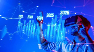 Hevesli bir kullanıcı, teknoloji ve veri analizinde gelecekteki büyüme projeksiyonlarını gösteren dinamik grafiklerle etkileşime geçen sanal gerçeklik kulaklığı takar. Raster.