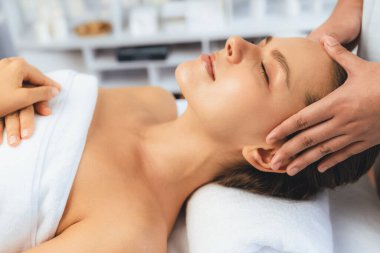 Kafkasyalı kadın stres önleyici kafa masajından ve lüks tatil beldesi ya da otel spa salonundaki modern ışık ortamında yüz güzelliği eğlencelerini şımartmaktan hoşlanıyor. Sessiz.