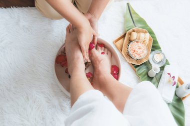 Kadınlar lüks spa salonlarında keyifli ayak masajlarına devam ederken, masör de hafif gün ışığı atmosferinde refleksoloji terapisi veya otel ayak spa 'sında. Sessiz.
