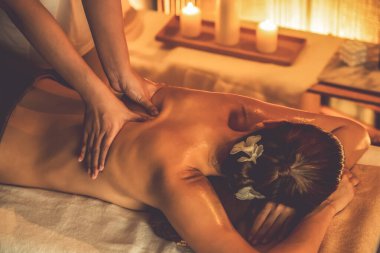 Beyaz kadın müşteri stres önleyici spa masajının keyfini çıkarıyor ve lüks otel ya da otelde sıcak mum ışığında güzellik teniyle eğleniyor. Sessiz.