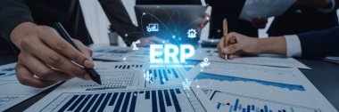 Business professionals review charts and documents while emphasizing ERP software for effective data management and enhanced project outcomes in a modern workplace. Trope