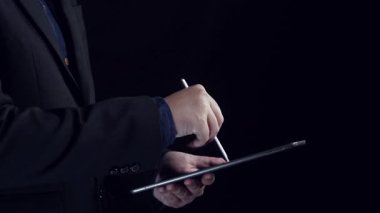 A businessman interacts with a tablet, showcasing a digital concept of data protection and cybersecurity through a futuristic visual representation and secure lock symbol. Qubit