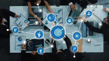 Engaging business meeting with a diverse team analyzing charts and graphs on digital devices, illustrating effective collaboration and strategic discussions in a modern workspace. Amity