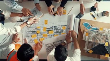 Yetenekli mühendis takımının ev modelini ölçerken konuştuğu tepeden tırnağa görüntü. Birlikte çalışan ve mühendislik inşaatı için plan yapan bir grup akıllı iç mimar. Hizalama.