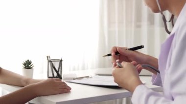 Hasta klinikte ya da hastane ofisinde doktor randevusuna gidiyor. Hastaların risk faktörünü tespit etmek için nabzını ölçmek için steteskopla doktor muayenesi ve teşhis semptomları. Ağır çekim. Katı.