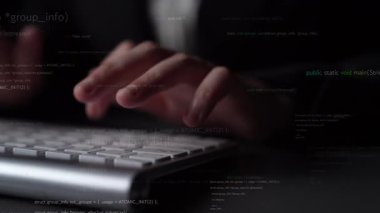 Close-up view of hands typing on a keyboard with code snippets in the background, illustrating the concept of software development and digital programming in action. Xenic