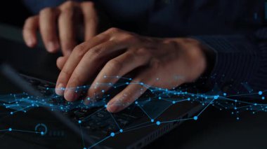 A close-up view of hands typing on a keyboard, enhanced by futuristic data visualization graphics and analytics charts showcasing the concept of digital transformation in business. Xenic