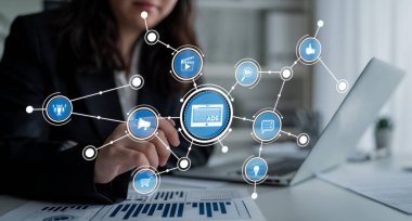 A business professional works on a laptop while analyzing digital advertising strategies. The visual showcases technology, data, and marketing elements enhancing modern commerce. Crux
