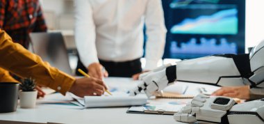 Veri analizi ve yenilikçi iş stratejilerindeki takım çalışmasını gösteren, insanlarla bir robot arasındaki dinamik ofis sahnesi. Noogenesis