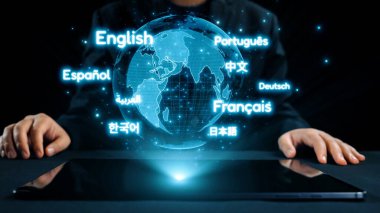 Küresel iletişimin görsel bir temsili, tabletten çıkan ve çok dilli etkileşim ve teknolojiyi vurgulayan çeşitli dil simgeleriyle çevrili dijital bir küreyi gösteriyor. Dörtgen