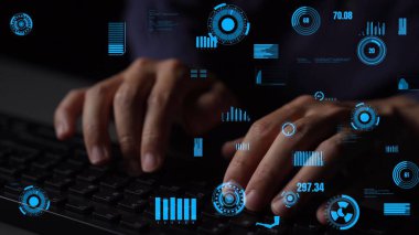 Gelişmiş dijital veri görselleştirmeleri ve grafikleri olan bir klavyede yazı yazan ellerin yakın görüntüsü. Bu görüntü teknoloji, siber güvenlik ve veri analizini temsil ediyor. Xenic