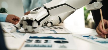 Çizelgeler ve grafiklerle dolu iş belgelerini incelerken insan eliyle uğraşan robotik bir kolu gösteren dinamik bir sahne. Noogenesis 'i simgeliyor.