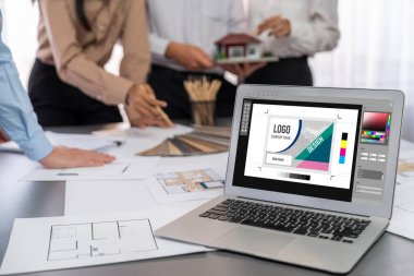 İç mimar tasarımcı grubu, daha kesin tasarım için planlar ve dizüstü bilgisayar ekran mimari yazılımı üzerinde birlikte tartışıyorlar. Modern ev tasarımı ve yenileme. İçgörü