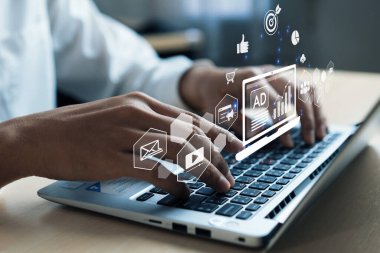 A close-up view of hands typing on a laptop, showcasing digital marketing symbols and concepts, emphasizing online advertising and social media strategies. XDMCP