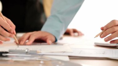 Mimarlar veya akıllı mühendislerin videosu mimari ofisindeki inşaat doğruluğu için taslak üzerinde ölçüm aracı, bölücü ve kalem el yazısı detaylarını kullanır. Eline odaklan. - Yakın çekim. Tanımlama.