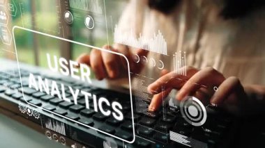 Professional hands typing on a keyboard with digital user analytics graphics in foreground showcasing data insights and technology concepts. Asymptotic smart data analytic.