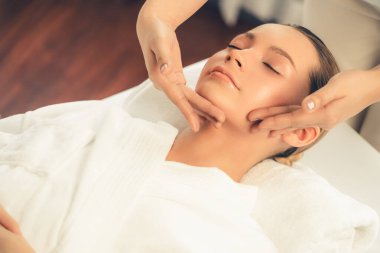 Kafkasyalı kadın stres önleyici kafa masajından ve lüks tatil beldesi ya da otel spa salonundaki modern ışık ortamında yüz güzelliği eğlencelerini şımartmaktan hoşlanıyor. Sessiz.