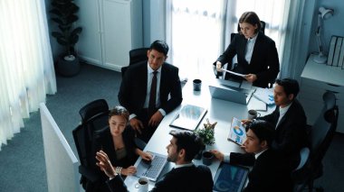 Yetenekli proje yöneticisinin üst düzey görüşü hisse senedi piyasası yatırım grafiğini yükseltirken, işadamı da fikri ve mevcut pazarlama stratejisini toplantı odasında açıklıyor. Takım birlikte çalışıyor. Müdürlük.