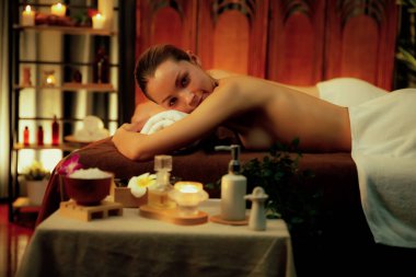 Aromaterapi masajı ambiyansı ya da spa salonu kompozisyon düzeneği bulanık kadınlara odaklı dekor mumları ve spa aksesuarları ile tatil köyü veya otel arka planında keyifli aroma spa masajı yapan. Sessiz.