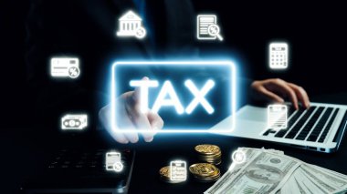 Bir iş adamı, vergi kavramlarını temsil eden dijital elementlerle etkileşime girer. Sahne, modern ofis ortamında para ve hesap makineleri de dahil olmak üzere finansal ayrıntıları yakalıyor. Dörtgen